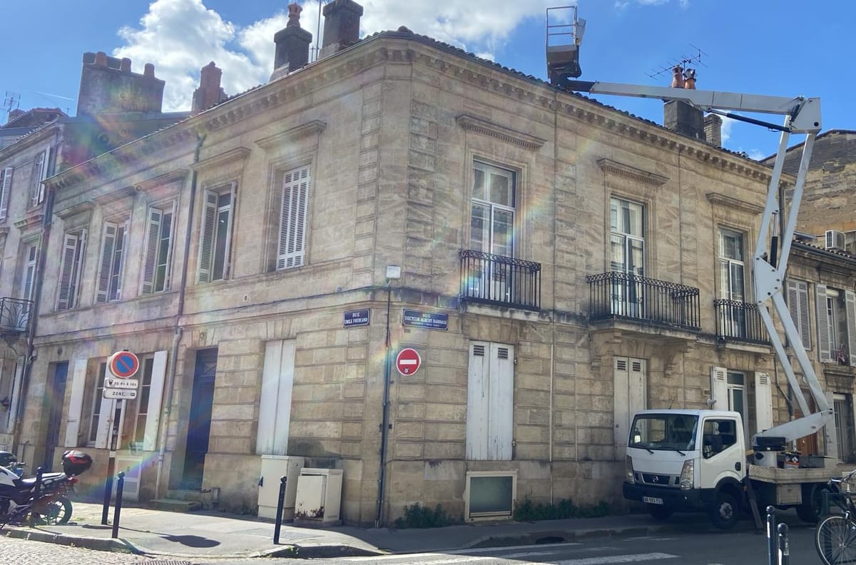 Intervention de couverture sur un immeuble ancien en pierre avec nacelle élévatrice, couvreur à Périgueux — illustration étanchéité toit-terrasse en Dordogne