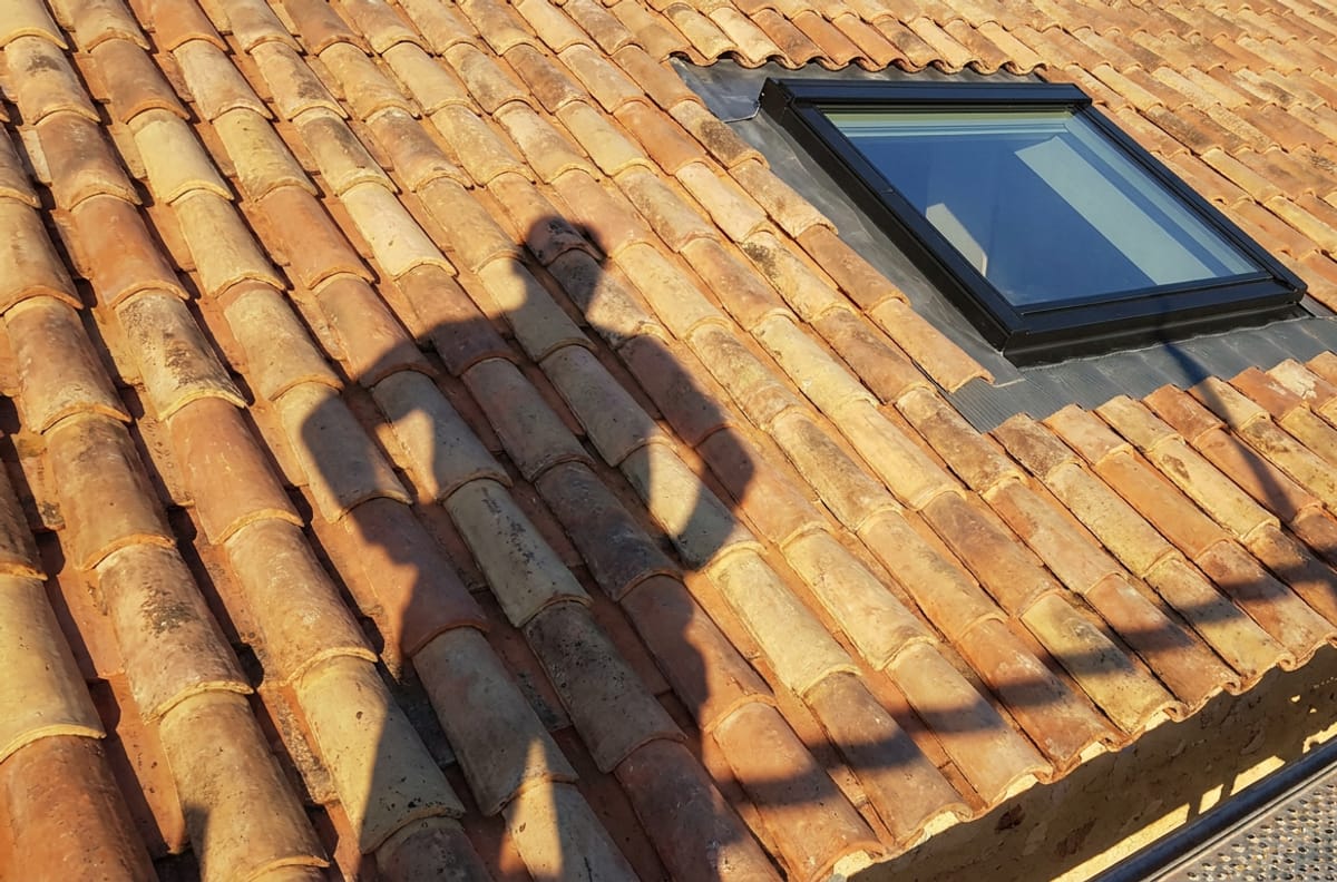 Couvreur sur toiture en tuiles canal lors d'un chantier de pose de Velux à Bergerac — couverture Saint-Laurent-des-Vignes et alentour